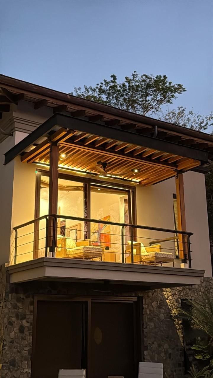 Teak balcony pergola lit at dusk